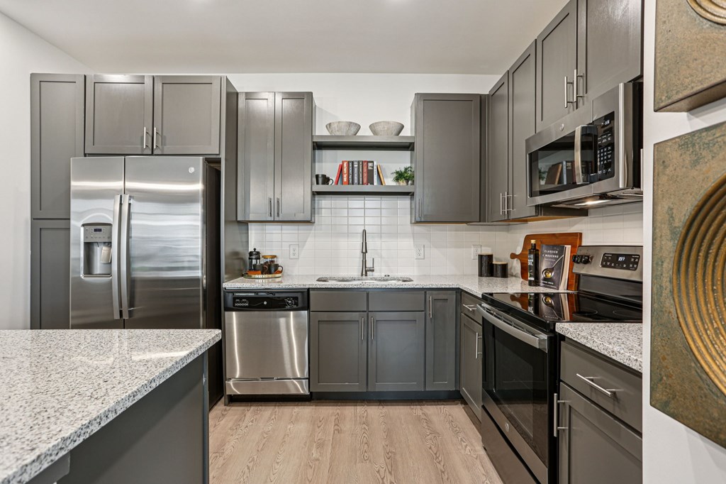 A modern kitchen with stainless steel appliances and dark wood cabinets.