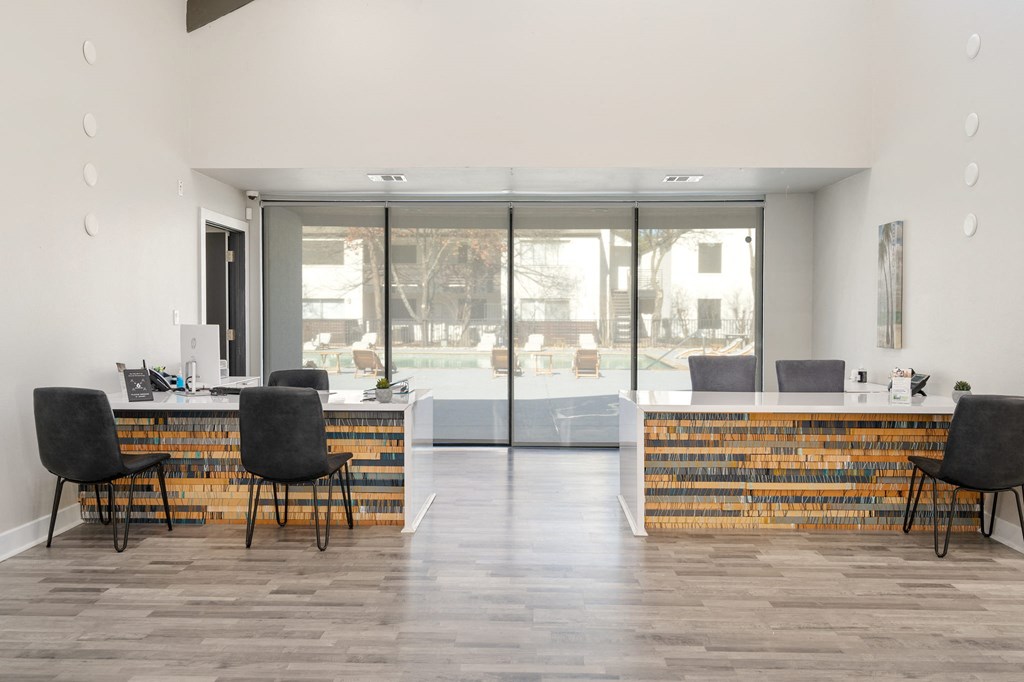 a reception area with a desk and chairs and a window