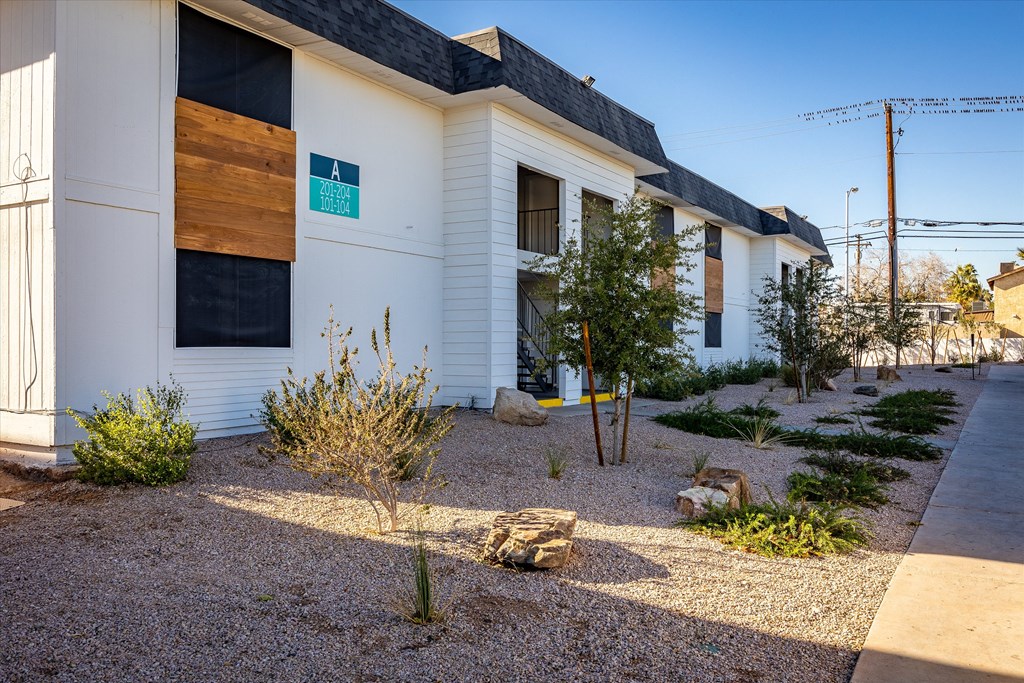 a view of the front of the building with landscaping and rocks