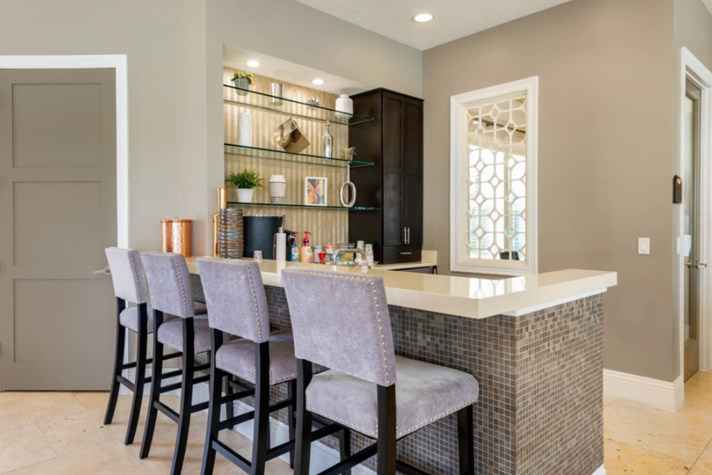 a kitchen with a long counter and a row of chairs in front of it