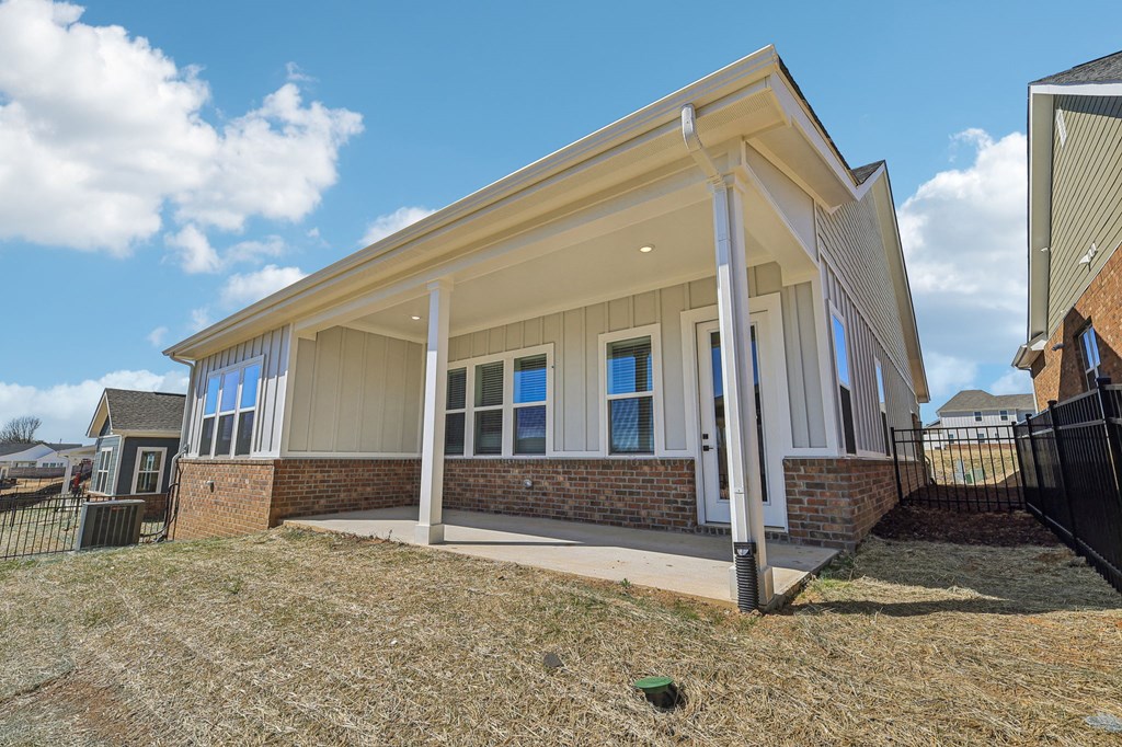A house with a white porch and a brick base is shown.