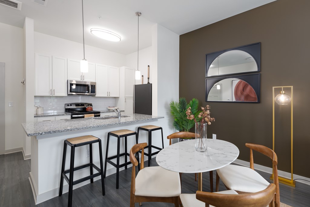 A kitchen with a bar area and a dining table.
