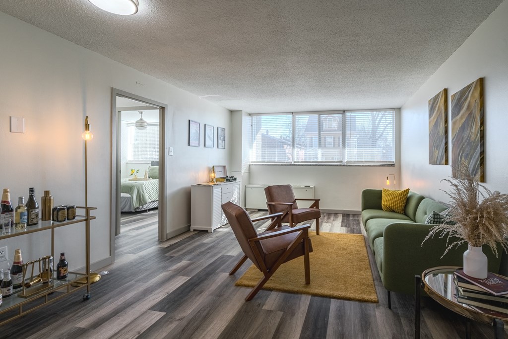an open living room with a couch and a chair and a dining room table