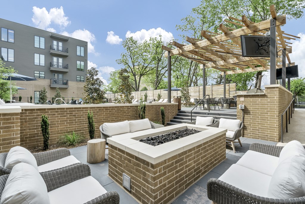 A patio with a fire pit and seating area.