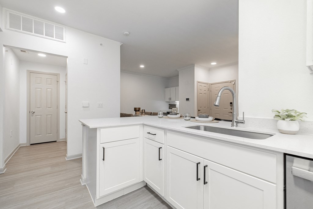 a large white kitchen with white cabinets and a sink