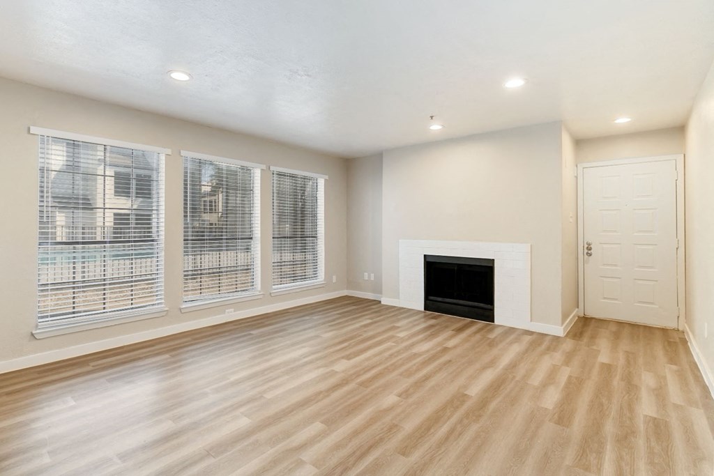 a living room with a fireplace and large windows