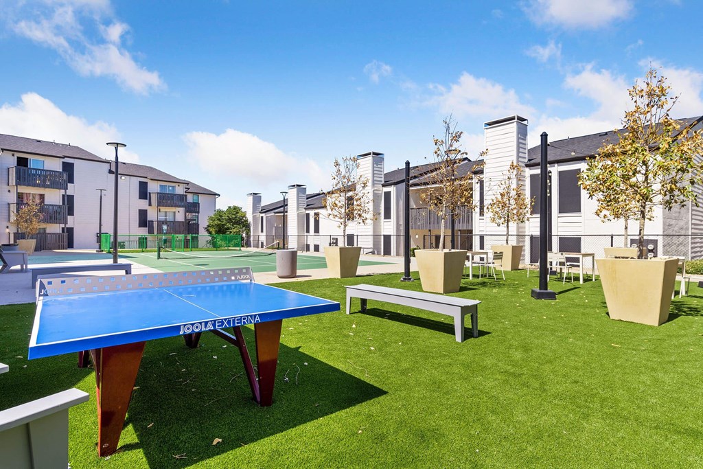 a communal area with a ping pong table and benches