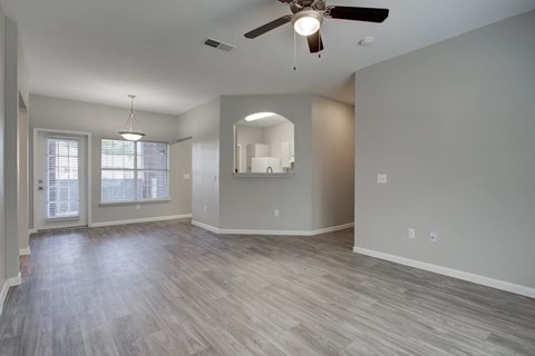 A spacious room with a ceiling fan and light fixture.
