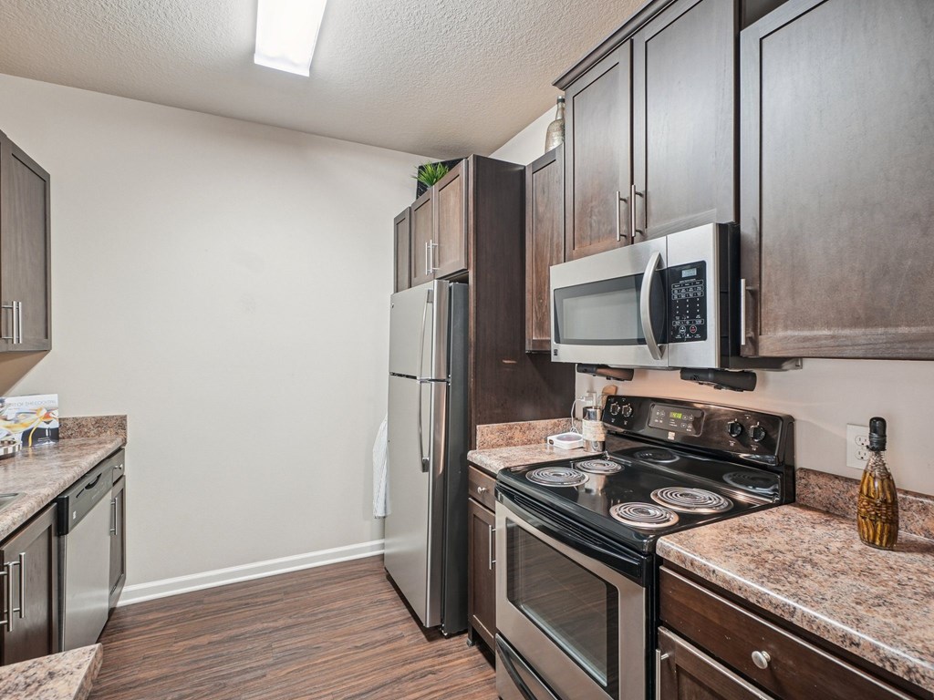 A kitchen with a black stove top oven and a black refrigerator.