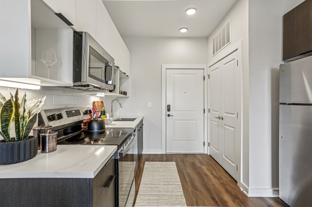 A modern kitchen with white cabinets and a stainless steel refrigerator.