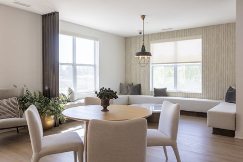 A modern dining room with a round table and chairs.
