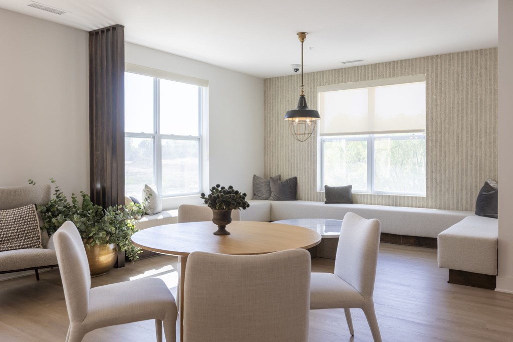 A modern dining room with a round table and chairs.