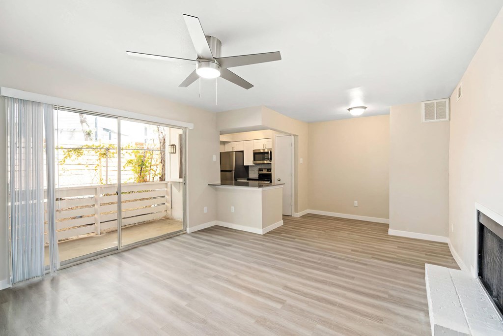 a living room with a fireplace and a ceiling fan