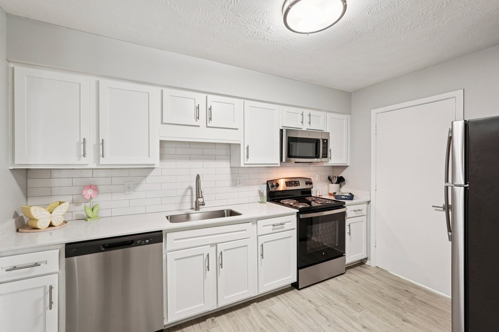 A kitchen with white cabinets and stainless steel appliances.