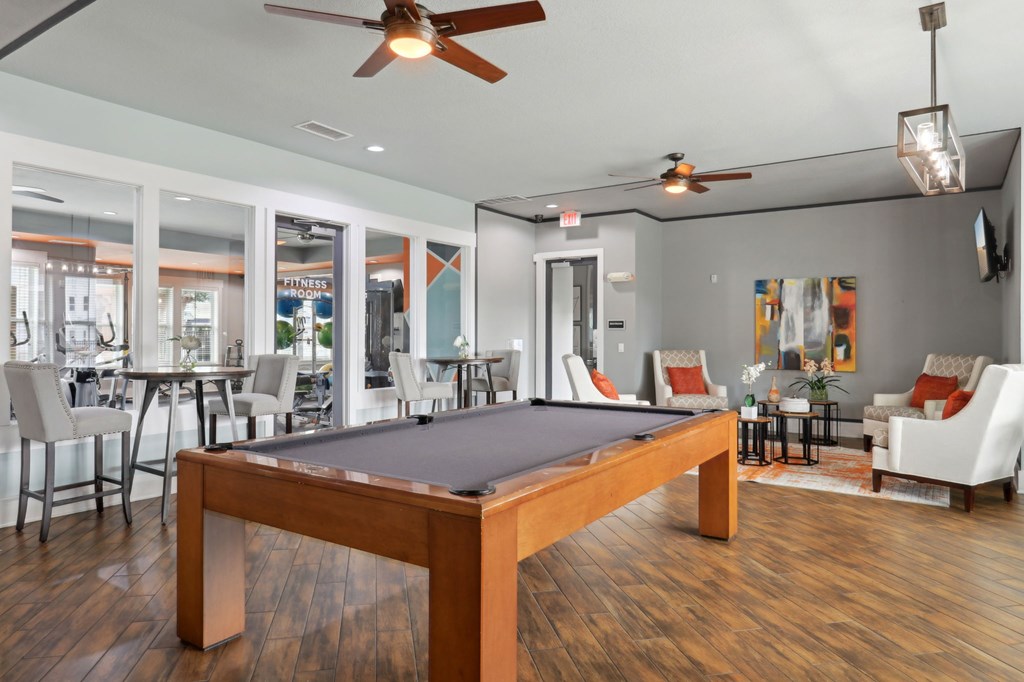 A room with a pool table and a ceiling fan.
