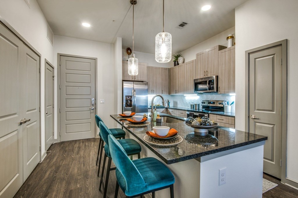 A kitchen with a table and chairs in front of a counter.
