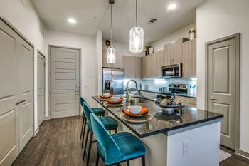 A kitchen with a table and chairs in front of a counter.