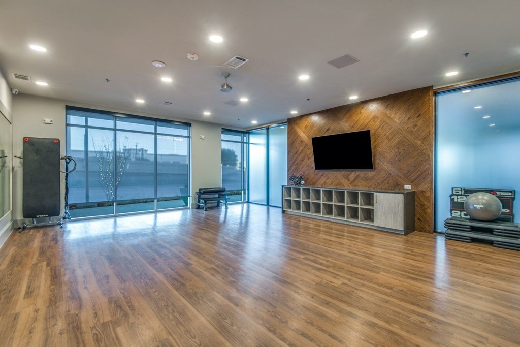 A spacious room with wooden floors and a large window.