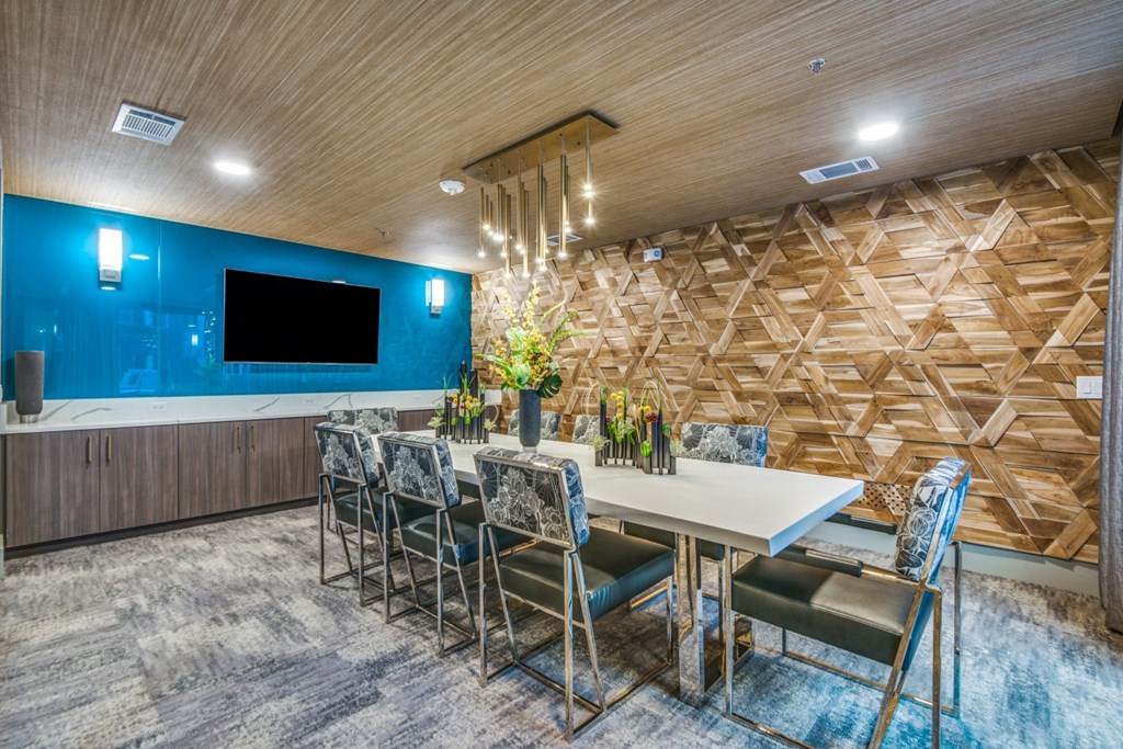 A dining room with a wooden wall and a TV.