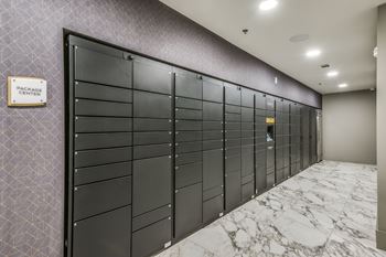 A row of black mailboxes are lined up against a wall.