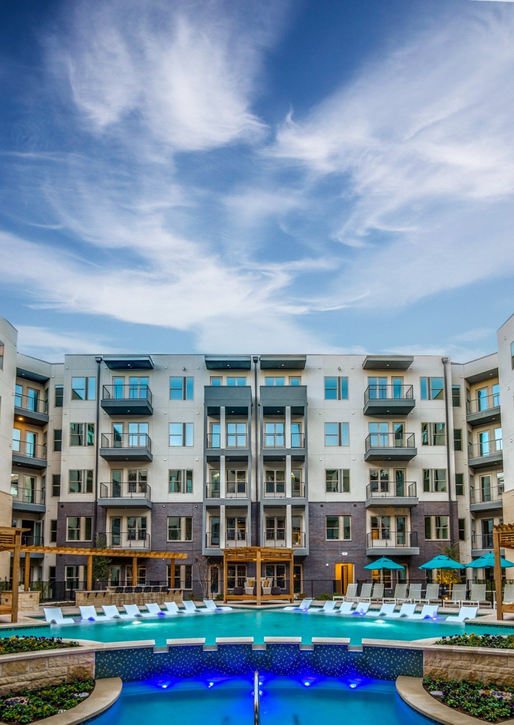 A large apartment complex with a pool in the foreground.