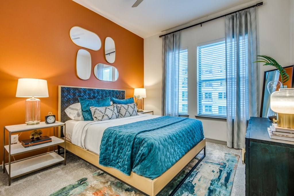 A bedroom with a bed, nightstand, and window.