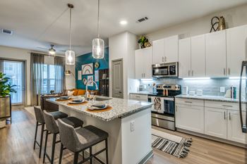 A kitchen with a white countertop and a blue backsplash.