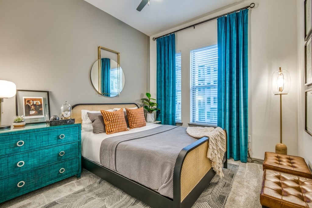 A bedroom with a bed, dresser, and mirror.