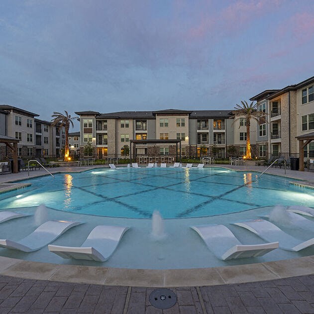 a large swimming pool in front of some apartment buildings