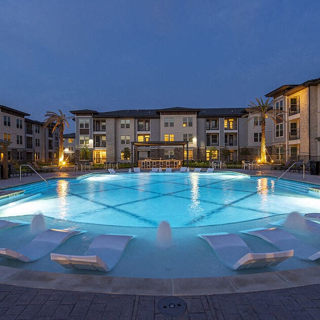 a large swimming pool in front of an apartment building