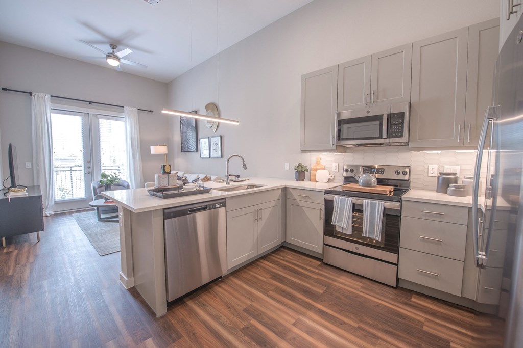 a kitchen with white cabinets and stainless steel appliances