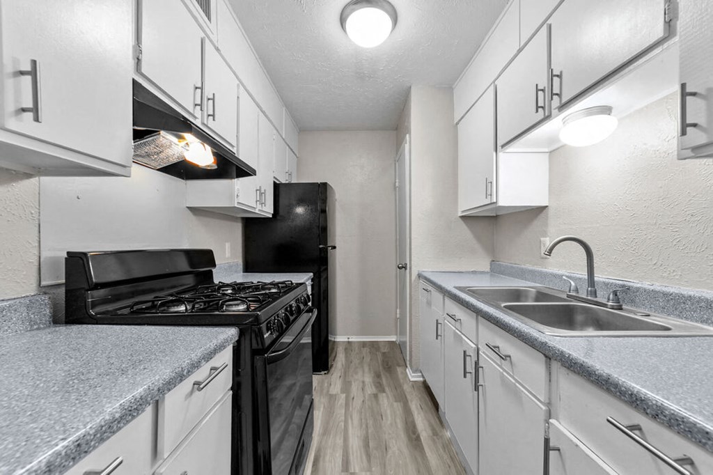 a kitchen with white cabinets and a black stove