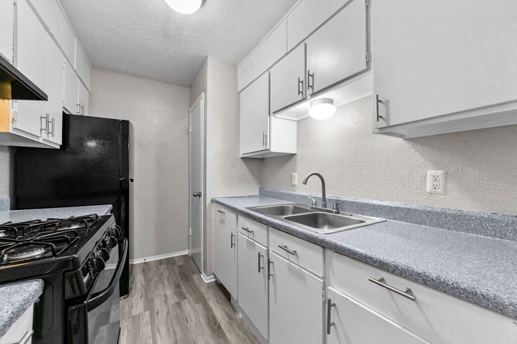 a kitchen with white cabinets and a sink