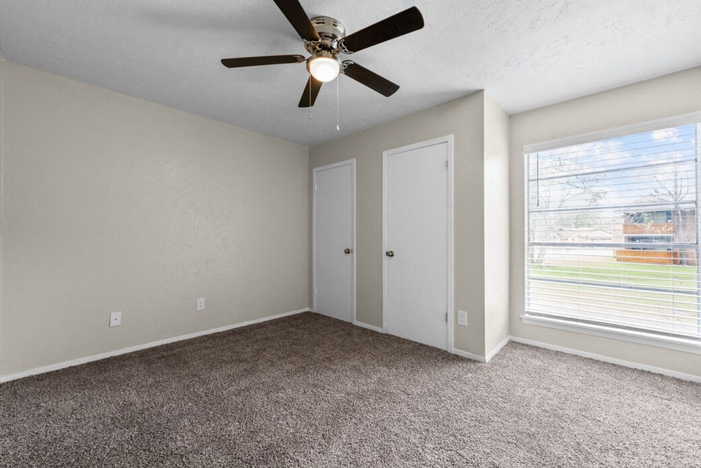 a bedroom with a ceiling fan and a window