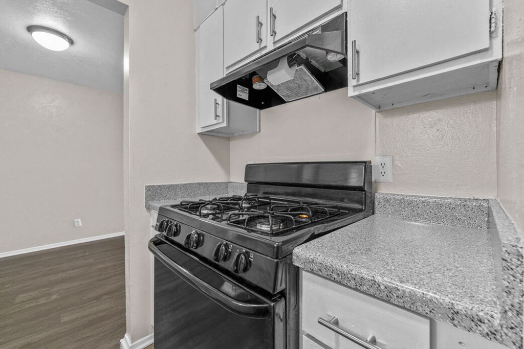 a kitchen with white cabinets and a stove top oven