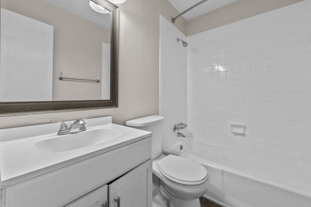 a white bathroom with a sink toilet and shower