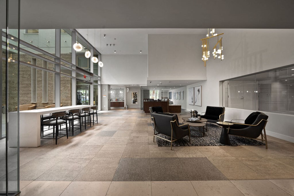 a large lobby with chairs and tables and a bar