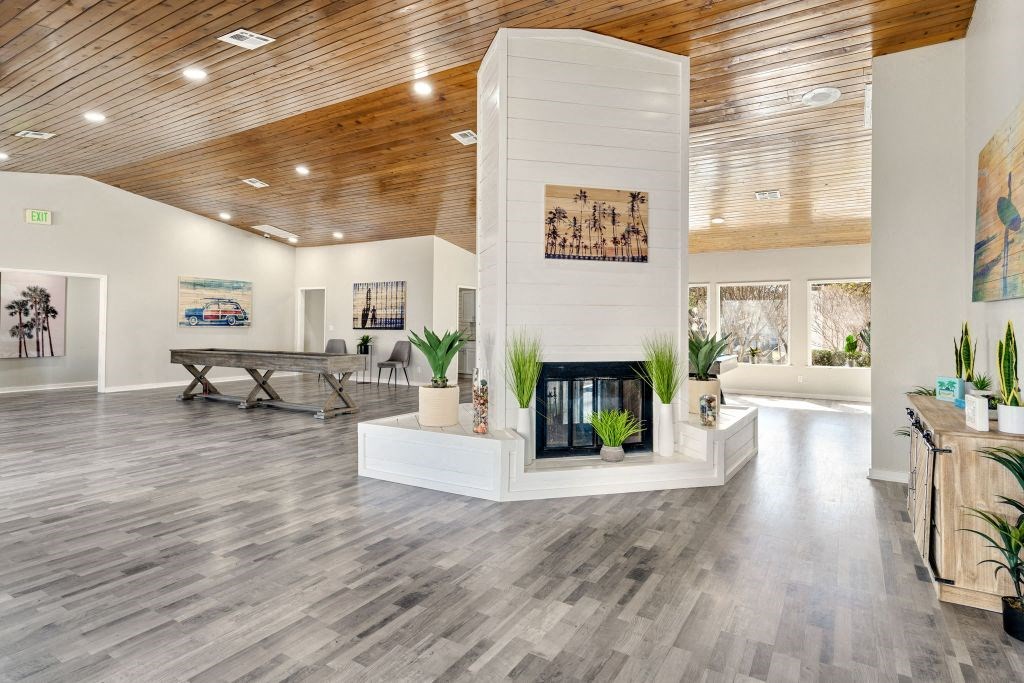 a living room with a fireplace and a wooden ceiling