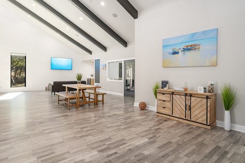a living room with a wooden floor and a table with chairs