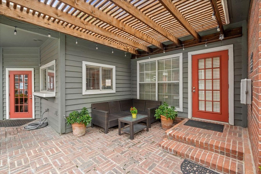 A house with a red door and a wooden pergola.