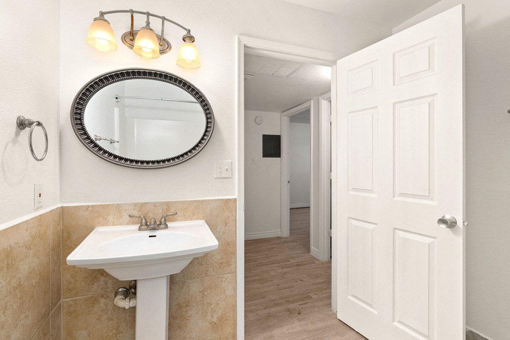 a white bathroom with a mirror and a sink