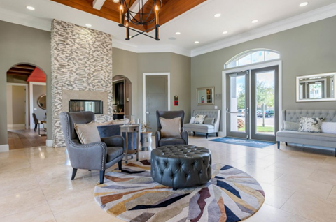 the living room has a stone fireplace and a large rug