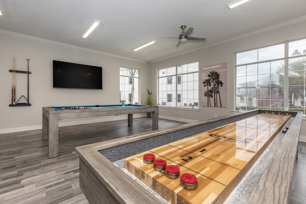 a games room with a shuffleboard table and a foosball table
