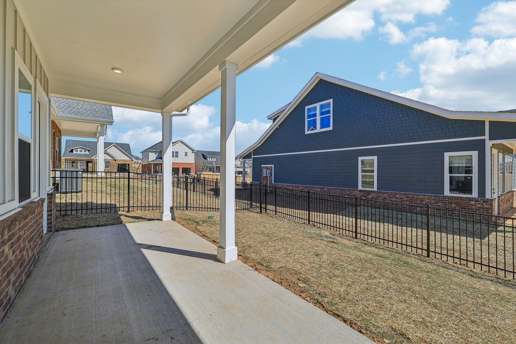 A blue house with a white roof and a black fence.