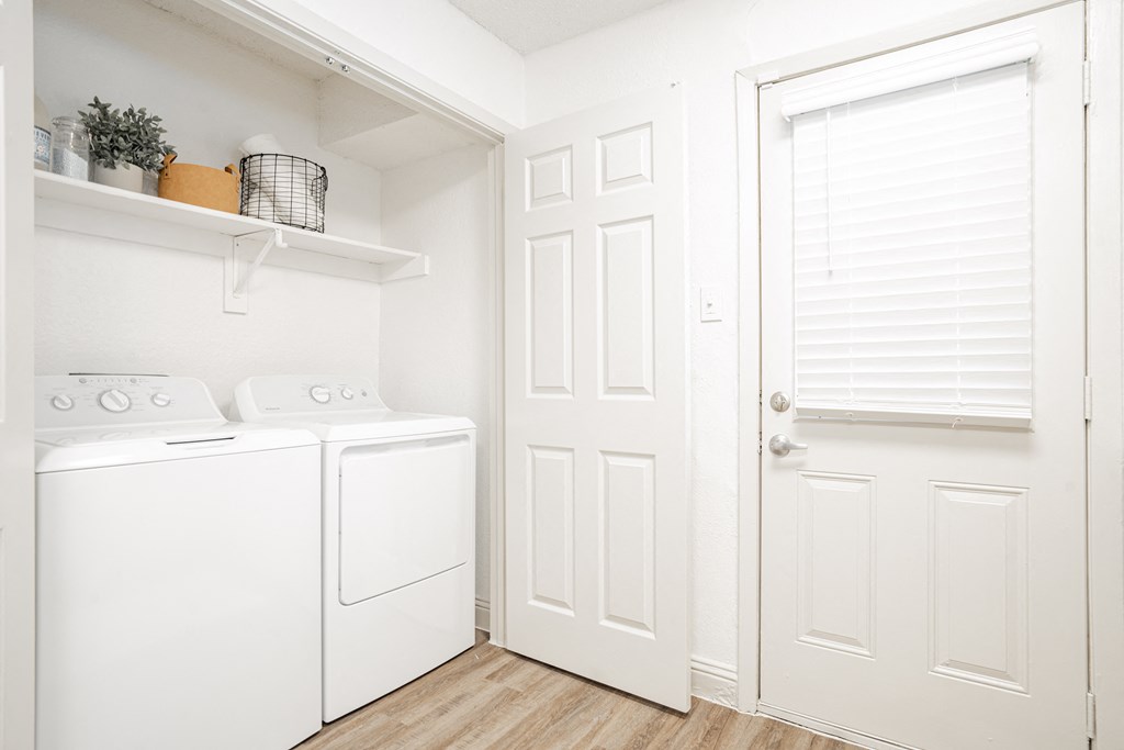 a laundry room with a washer and dryer and a white door