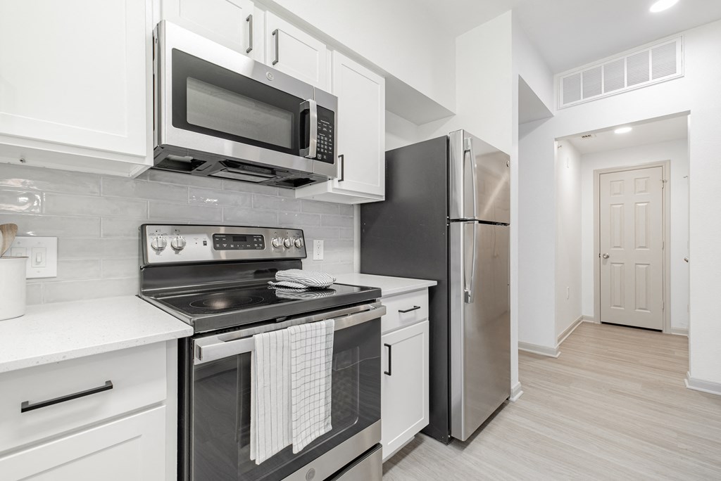 a kitchen with stainless steel appliances and white cabinets