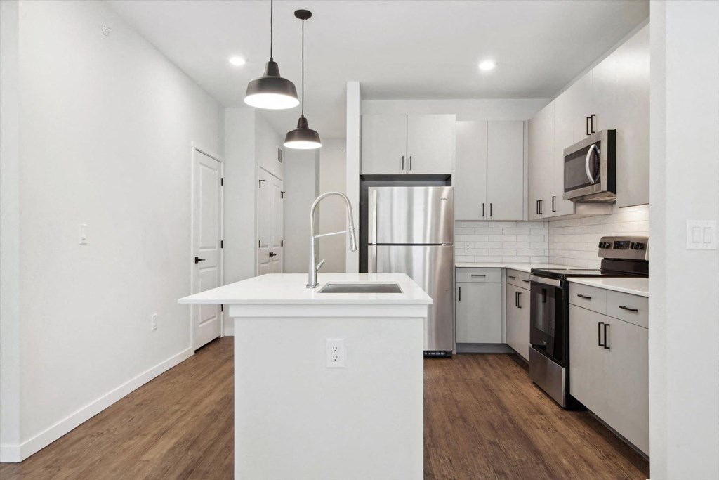 a kitchen with white cabinets and a white counter top