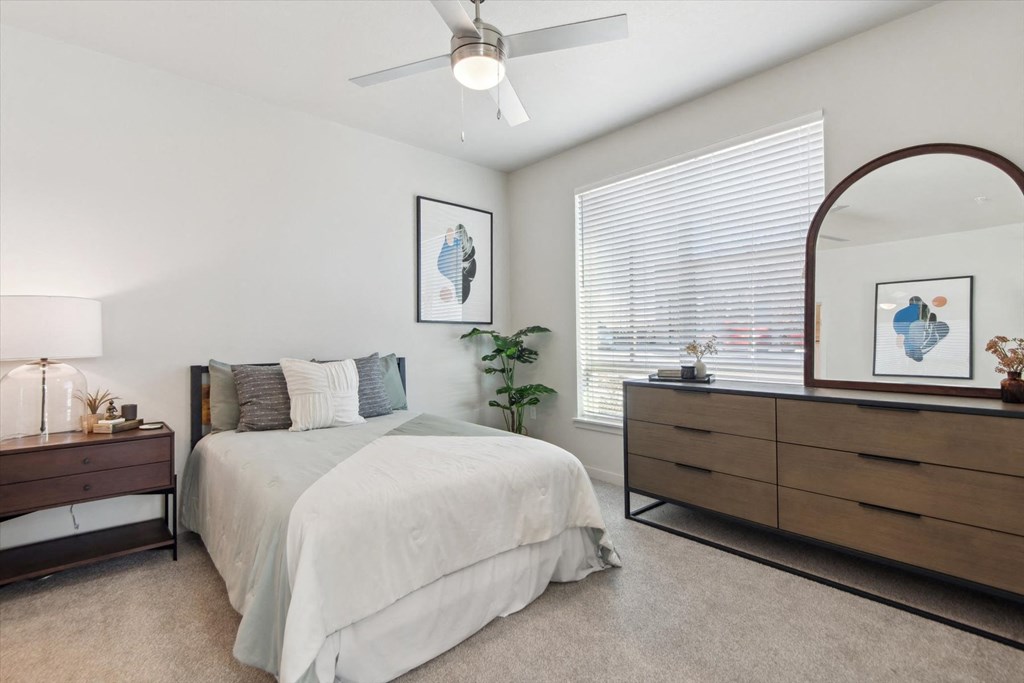 A bedroom with a bed, dresser, and mirror.