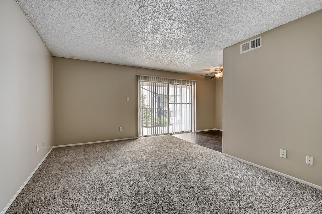 an empty living room with a sliding glass door