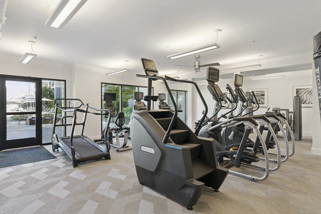 A gym with treadmills, elliptical machines, and other exercise equipment.